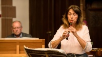 Frau spielt auf Instrument etwas vor