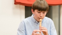 Ein Junge spielt Blockflöte