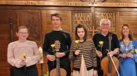 Fünf Musiker mit Blumen in der Hand auf der Bühne