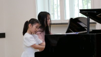 Zwei junge Pianistinnen spielen Klavier zu vier Händen