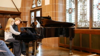 Zwei junge Pianisten spielen Klavier zu vier Händen