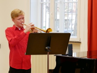 Junge, der Trompete spielt