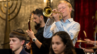 Ein Junge mit Trompete inmitten anderer Musiker