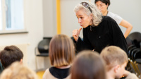 Kinder lauschen den Erklärungen einer Frau